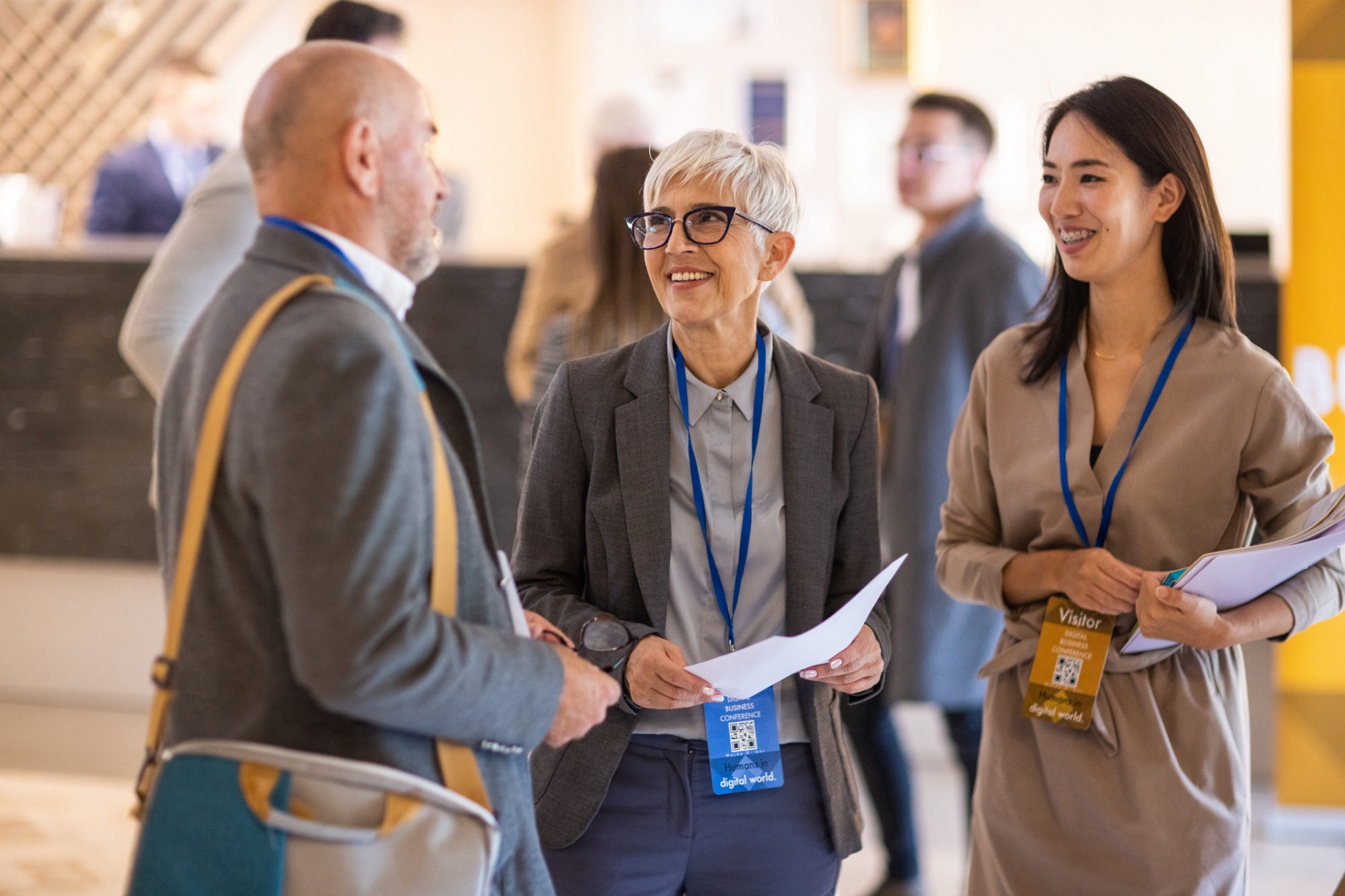 business people socializing at conference for refer a friend | © miodrag ignjatovic / E+ / Getty Images